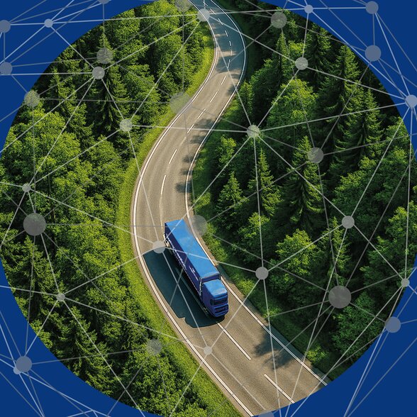 Lkw fährt auf kurvenreicher Landstraße durch Wald.