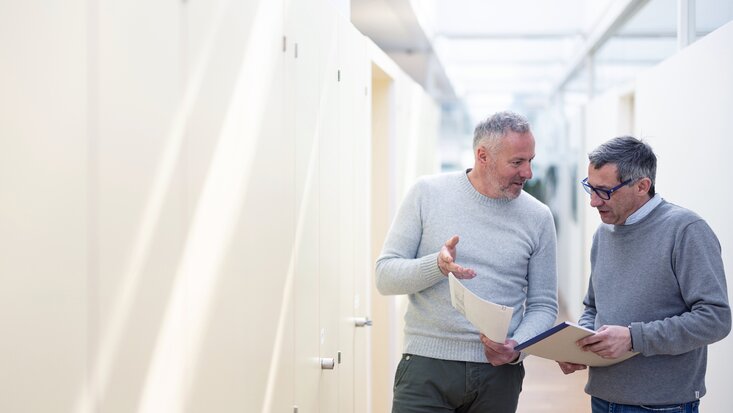 Fotografie von zwei Lagermax-Mitarbeiter waehrend einer kurzen Abstimmung
