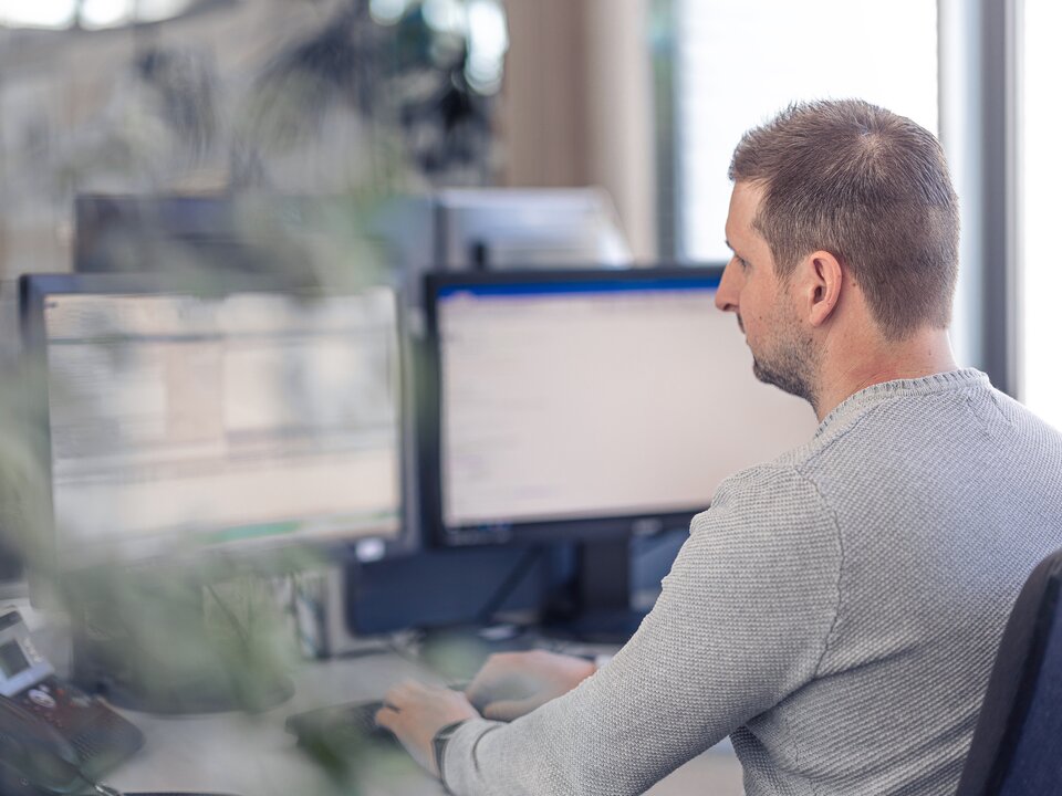 Foto eines Lagermax-Mitarbeiters bei der Computer-Arbeit im Office im Querformat