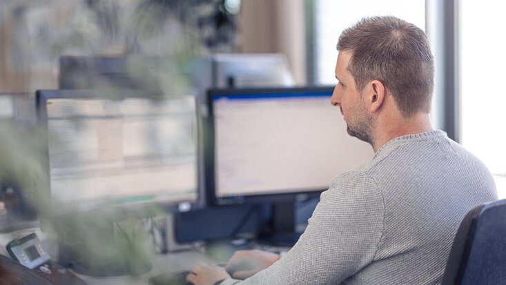 Foto eines Lagermax-Mitarbeiters bei der Computer-Arbeit im Office im Querformat