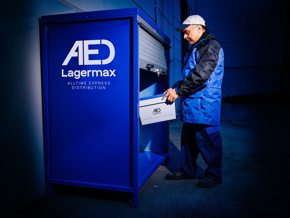 Mann stellt paket in Pick-Up Drop-Off Box.