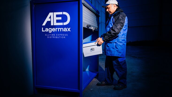 Mann stellt paket in Pick-Up Drop-Off Box.