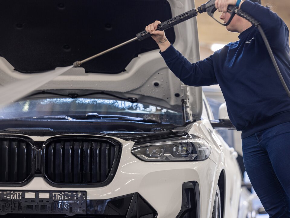 Mann reinigt Motor mit Hochdruckreiniger Nahaufnahme