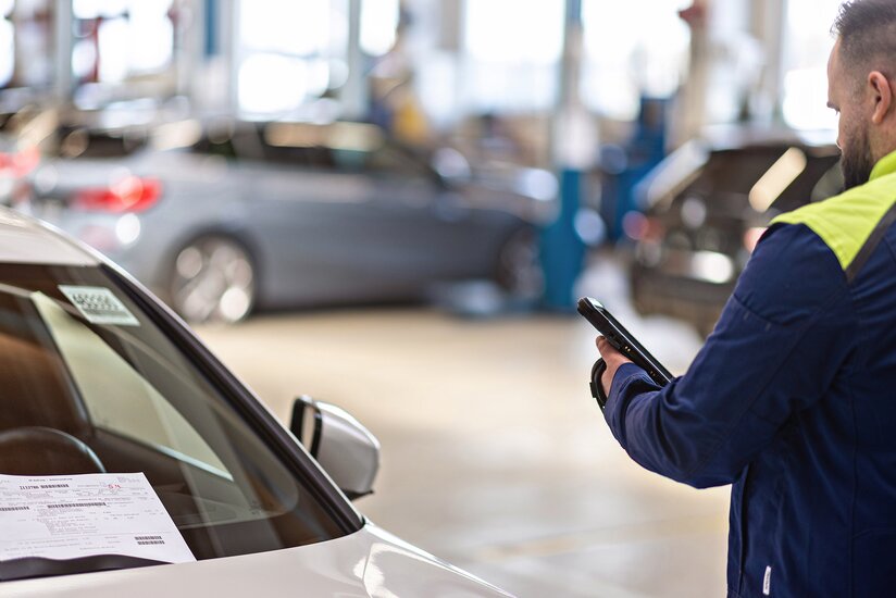 Mitarbeiter scannt Fahrzeugdaten auf Lieferschein Nahaufnahme