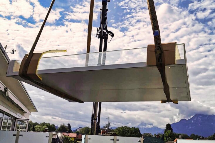 Kran hebt Ware von Terasse.