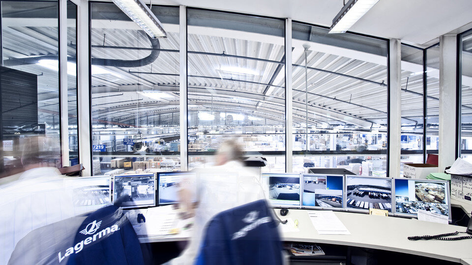Zwei Mitarbeiter unscharf von hinten mit Blick in Halle.