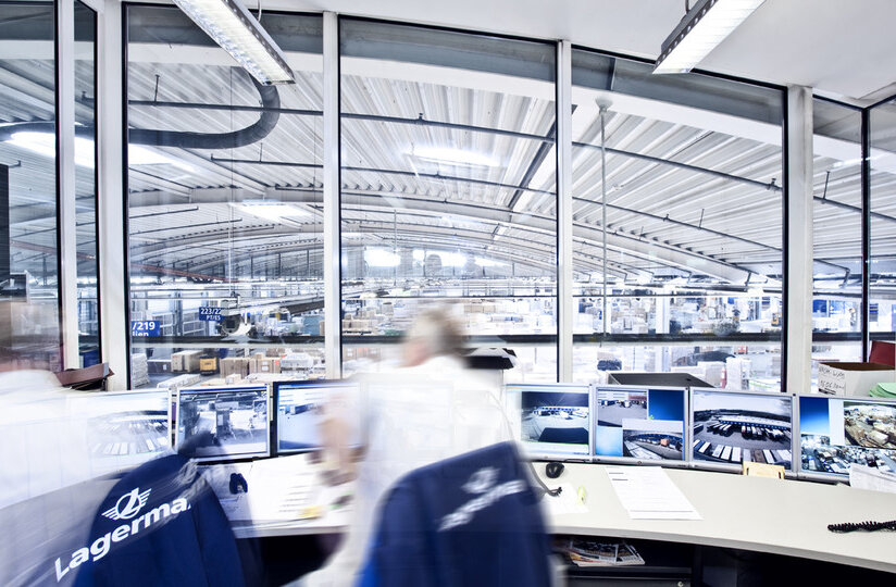 Zwei Mitarbeiter unscharf von hinten mit Blick in Halle.
