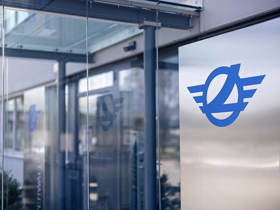 Seitenansicht Vordach zum Eingang mit Glastür und Logo