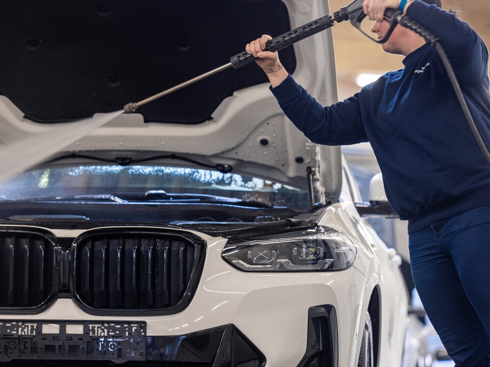 Ein Fahrzeug wird im Rahmen der Pre Delivery Inspection von Innen mit Wasser gereinigt