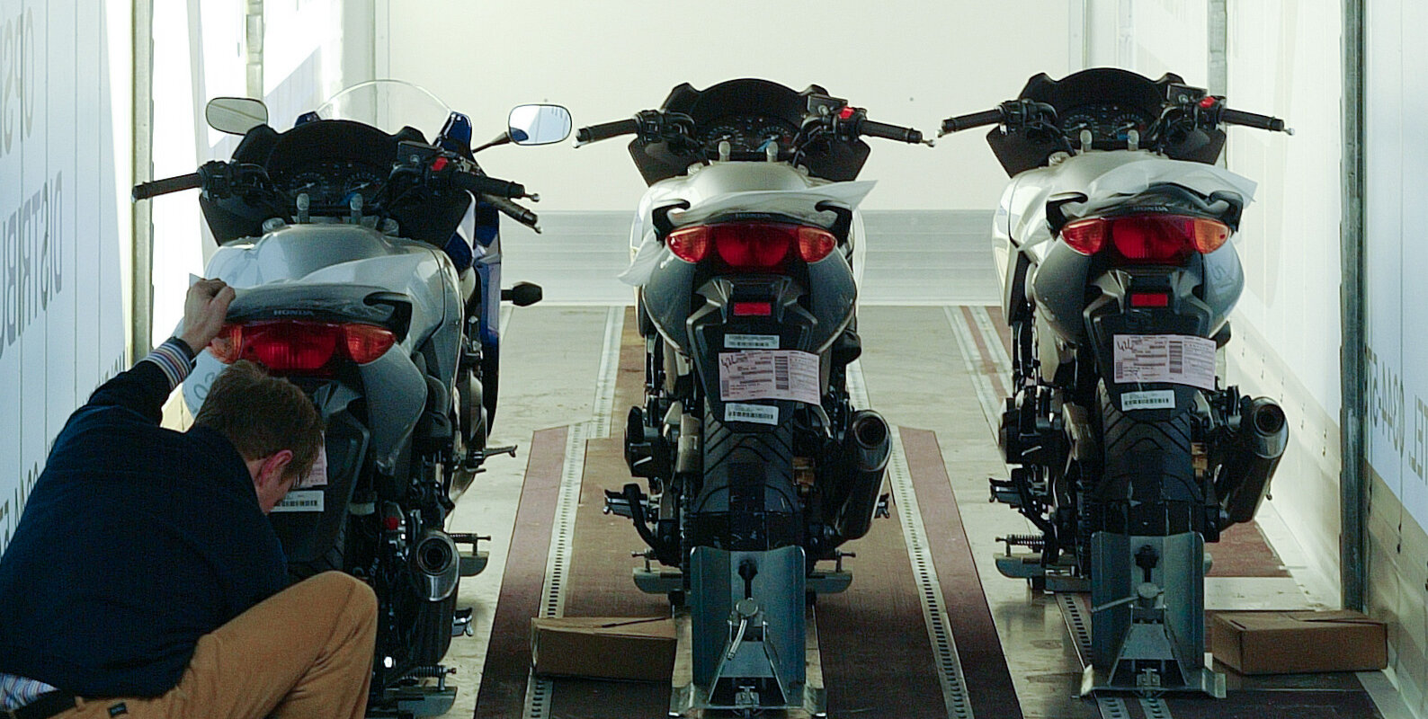 Man sieht einen Lagermax Mitarbeiter beim Verladen von Motorrädern in einen Transport LKW