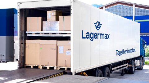 Man sieht einen mit Boxen voll beladenen Lagermax LKW an einer Rampe.