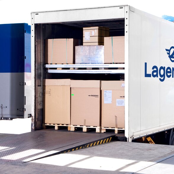 Man sieht einen mit Boxen voll beladenen Lagermax LKW an einer Rampe.