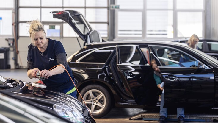 Frau poliert Motorhaube Lagermax Hochformat 