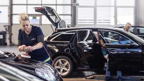 Frau poliert Motorhaube Lagermax Hochformat 