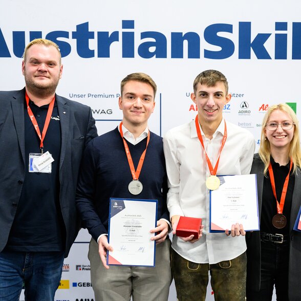 Gruppenbild - Drei Männer und Frau mit Urkunde und Medaille