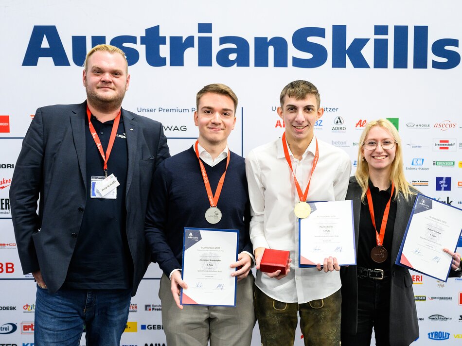 Gruppenbild - Drei Männer und Frau mit Urkunde und Medaille