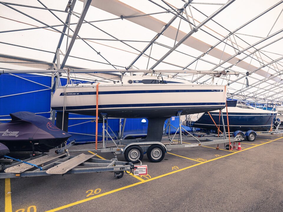 Man sieht Boote und Mini Yachten eingeparkt in einer Lagerhalle