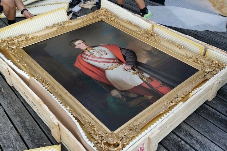 Mitarbeiter verpacken Gemälde in Holzkiste.