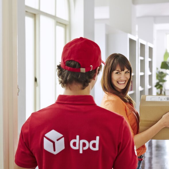 DPD Bote übergibt Paket bei Wohnungstür an Frau