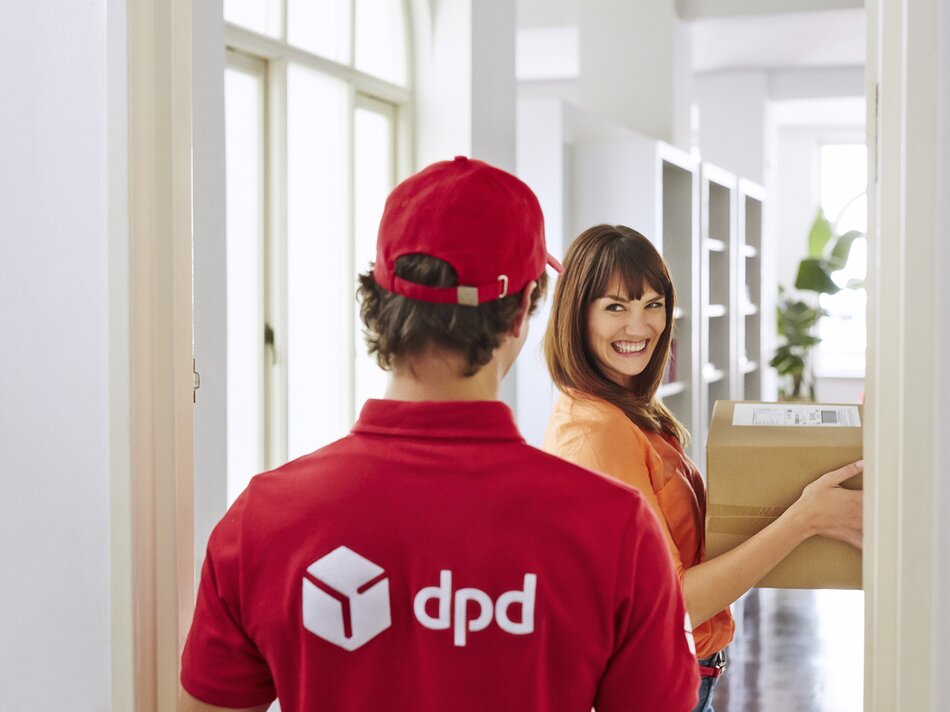 DPD Bote übergibt Paket bei Wohnungstür an Frau