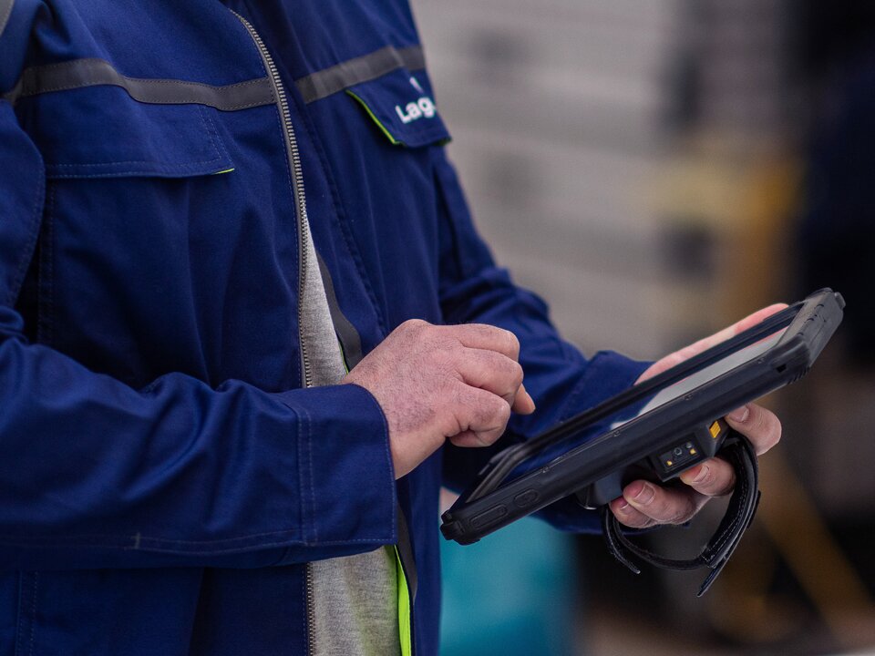 Ein Portrait von einem Lagermax Mitarbeiter mit einem Tablet im Hochformat