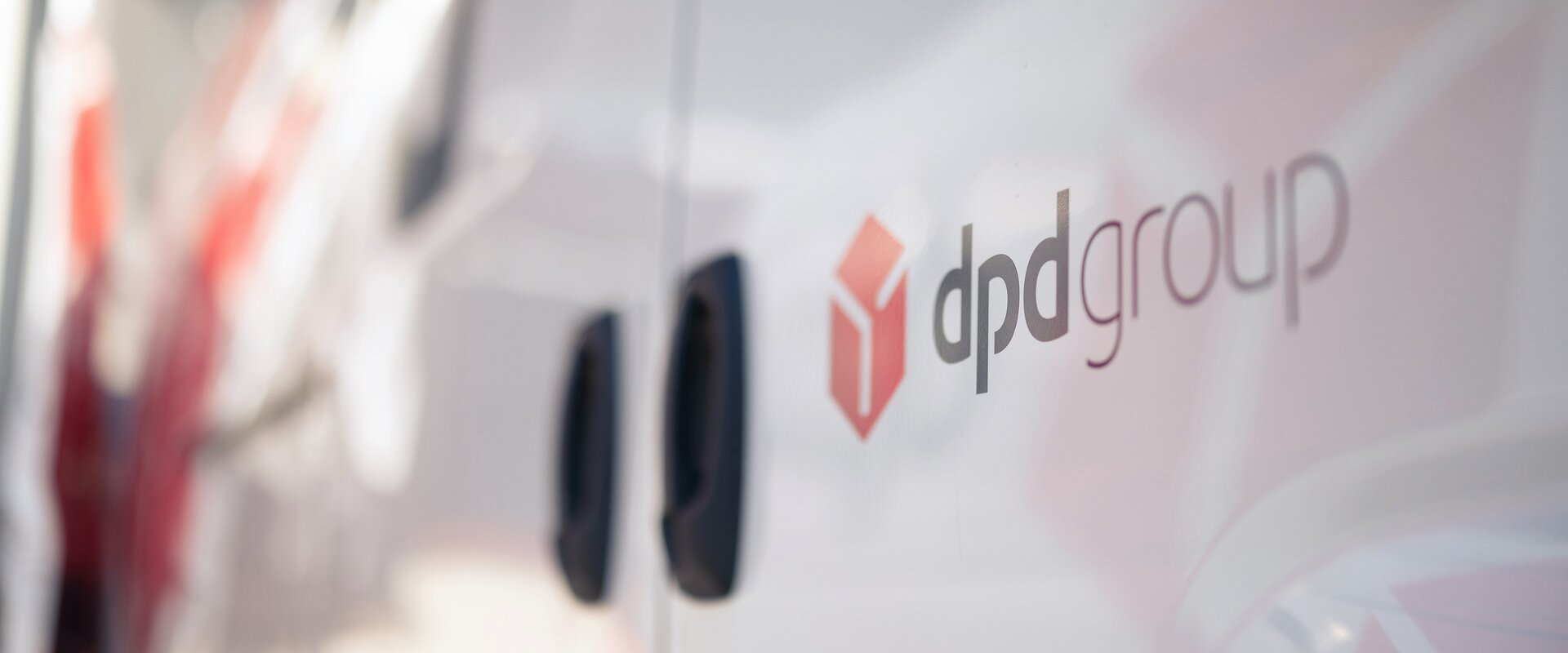 Man sieht das dpdgroup Logo in der Nah-Aufnahme an einer Autotuer