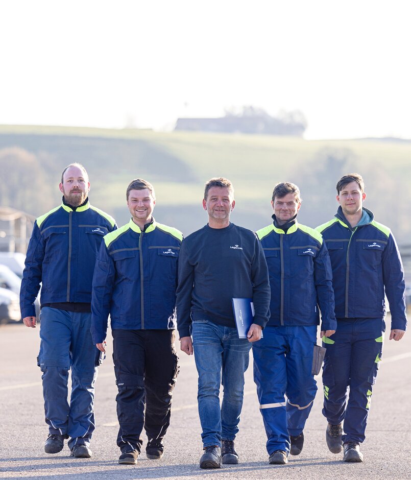 Lagermax Mitarbeiter Team geht auf Parkplatz nach vorne