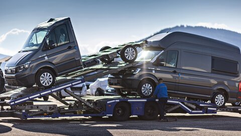 Es ist ein Transporter mit einem Sattelzug und einem PKW beladen