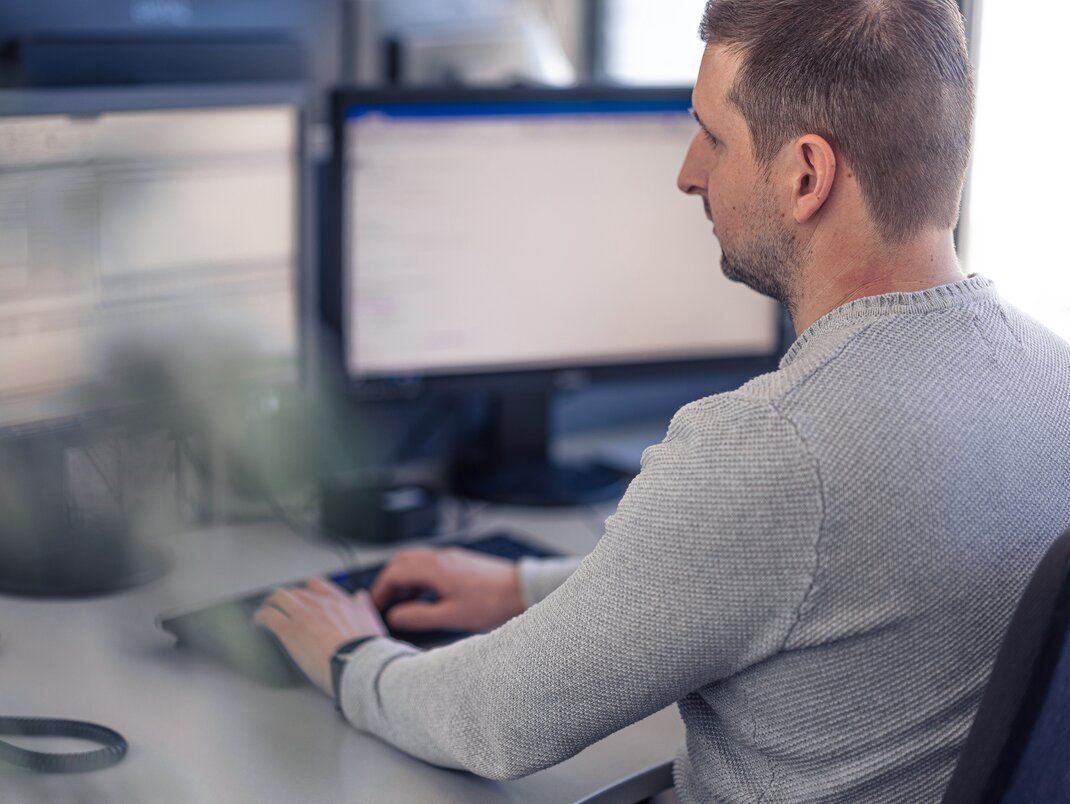 Foto eines Lagermax-Mitarbeiters im Buero bei der Computer-Arbeit