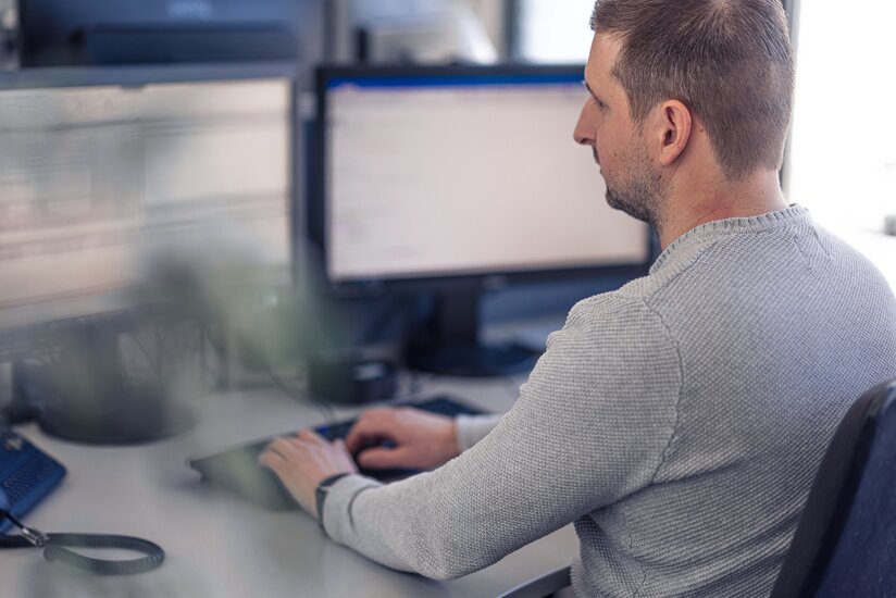 Foto eines Lagermax-Mitarbeiters im Buero bei der Computer-Arbeit