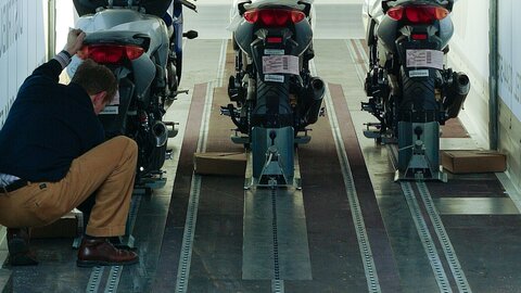 Man sieht einen Lagermax Mitarbeiter beim Verladen von Motorrädern in einen Transport LKW